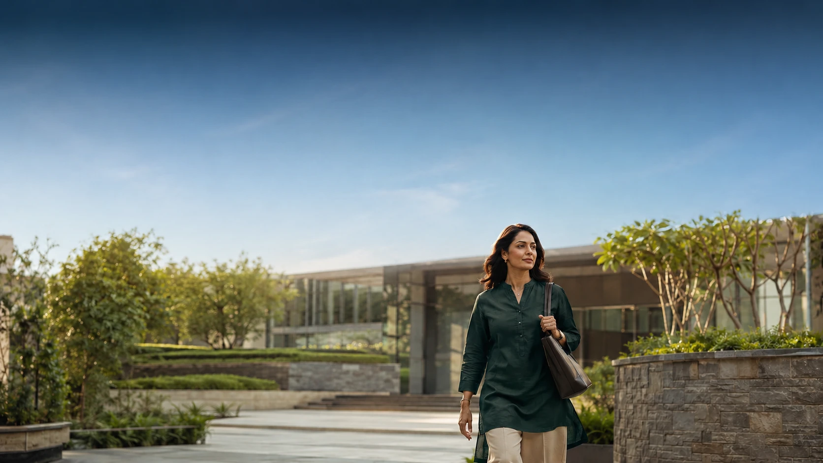 A woman walking through a sunlit garden courtyard